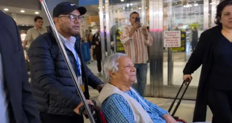 Muhammad Yunus Protest: न्यूयॉर्क के JFK एयरपोर्ट पर मोहम्मद यूनुस का विरोध, प्रदर्शनकारियों ने लगाए गंभीर आरोप